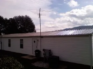 New metal roof on a single wide mobile home with a TV antenna in Hawley