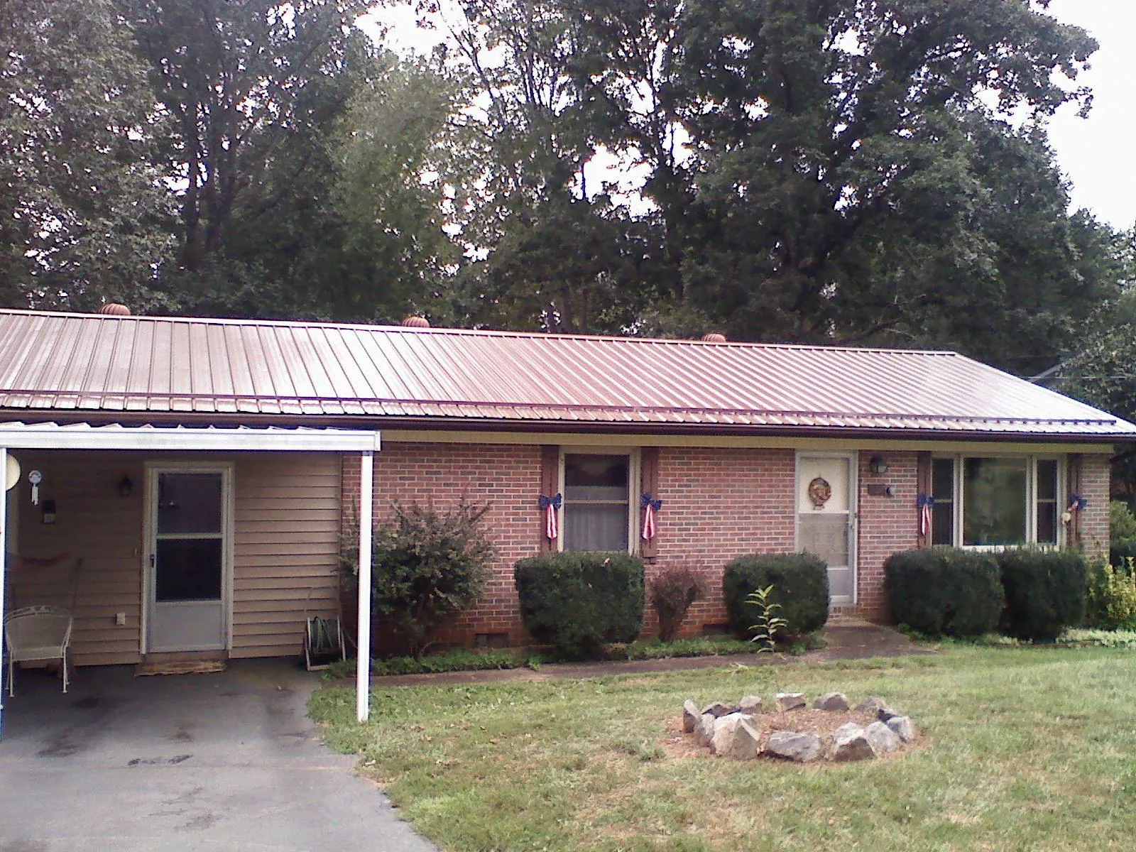 Bronze metal roof and carport on a brick ranch home — Roof Repair work by our crew in Hawley